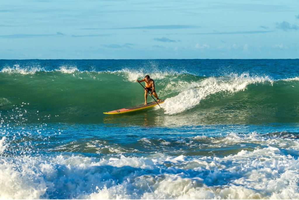 A man riding a large wave on a paddleboard